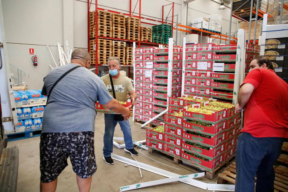 Una de las entidades de reparto recoge cajas de uvas de la nave del Banco de Alimentos