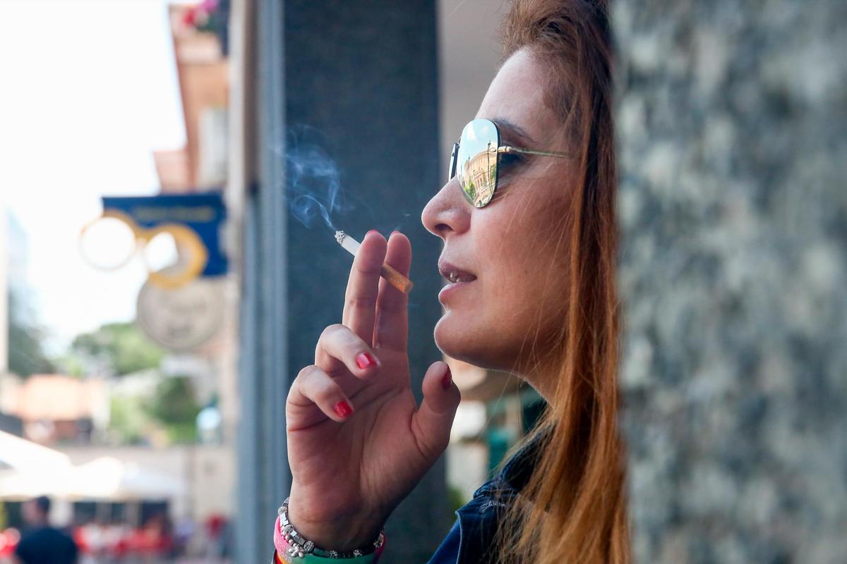 Una mujer fuma en la calle