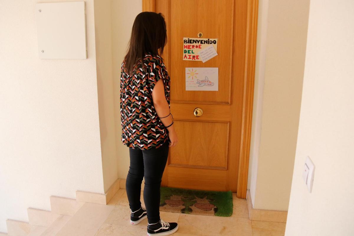 Una joven observa las dedicatorias de los vecinos en la puerta del domicilio del piloto.