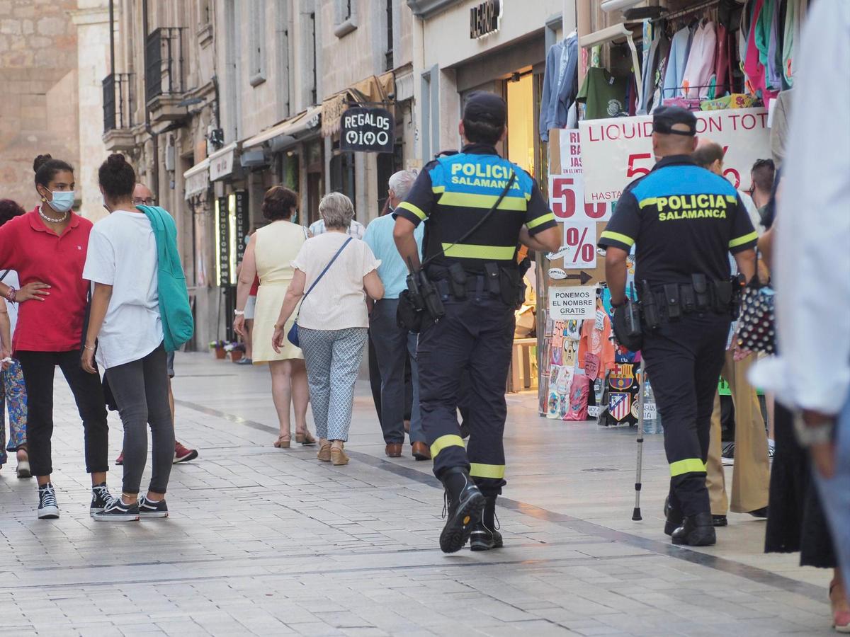 Dos policías locales caminando por el centro de la ciudad.