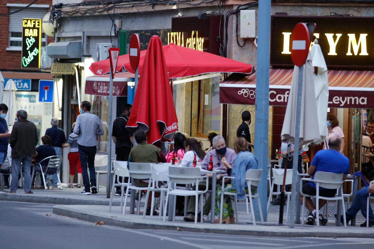 Varias personas sentadas en una terraza en la ciudad.