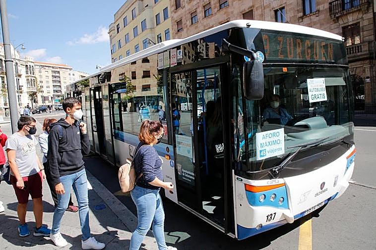Usuarios del autobús urbano subiendo al autobús de la línea 9 en la plaza del Empresario.