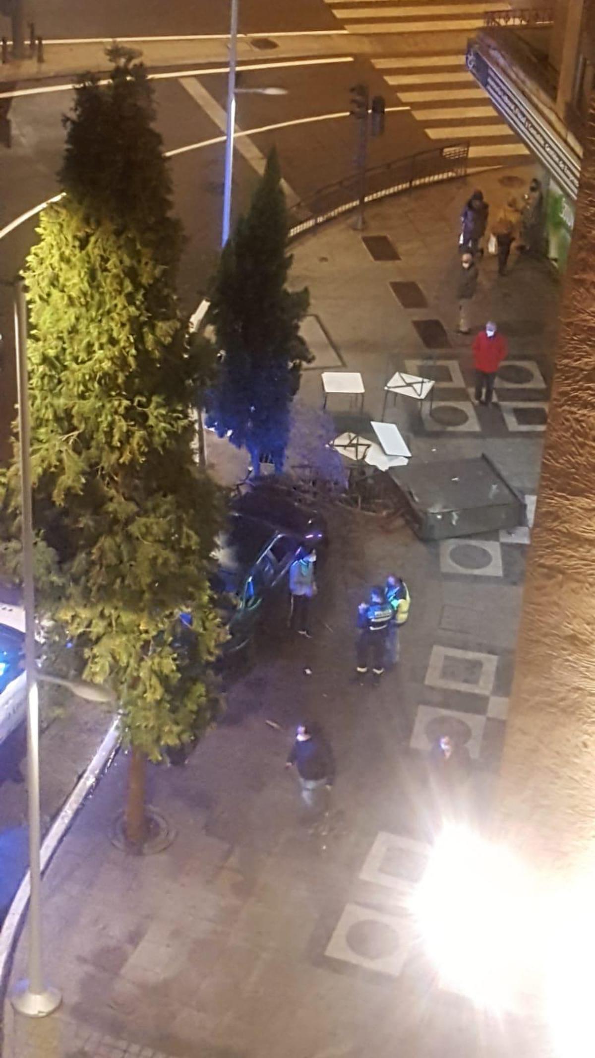 Agentes de Policía Local junto al coches estampado contra el cuadro de luz.