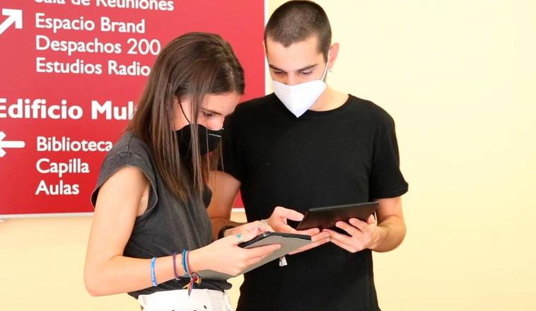 Dos estudiantes observan las aplicaciones presentadas.