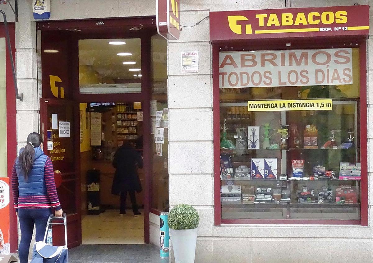 Una mujer esperando su turno para comprar tabaco en un estanco. I GUZÓN