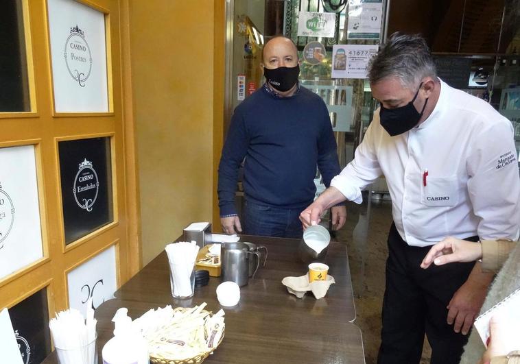 Un camarero sirve un café para llevar en un establecimiento del centro.