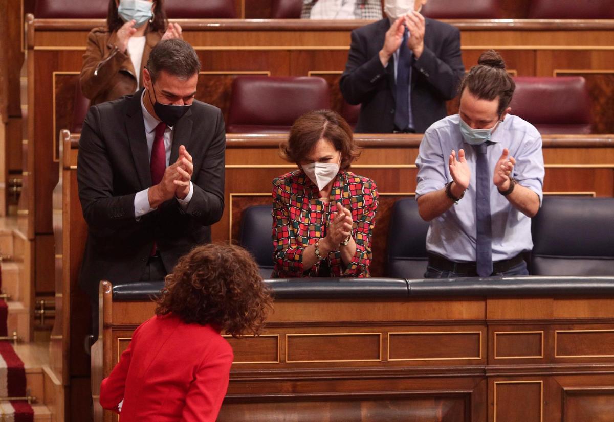 El presidente Pedro Sánchez y los vicepresidentes Carmen Calvo y Pablo Iglesias aplauden a la ministra de Hacienda, Maria Jesús Montero.