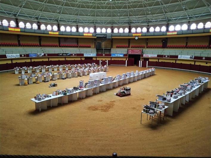 La plaza de toros con las mesas de los lotes que se entregan a las familias.