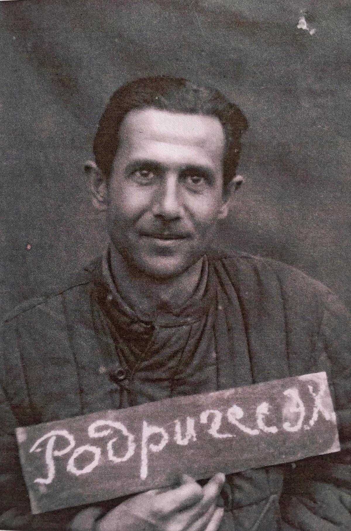 En la foto del archivo de Carmen Calvo Jung, Hermógenes en su ficha carcelaria, con la chaqueta del gulag y mostrando su nombre en caracteres cirílicos: “Rodríguez E (rmógenes) J(esusovich).