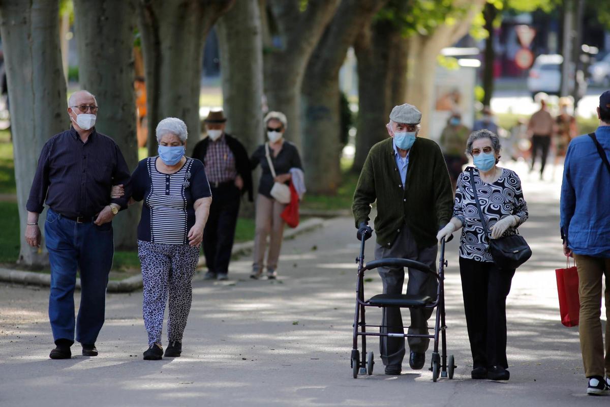 Mayores paseando con mascarilla.