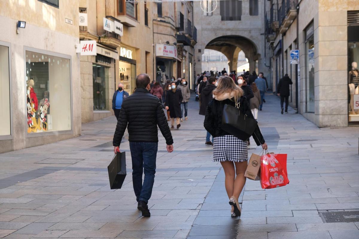 Personas con bolsas de compras en la calle Toro.