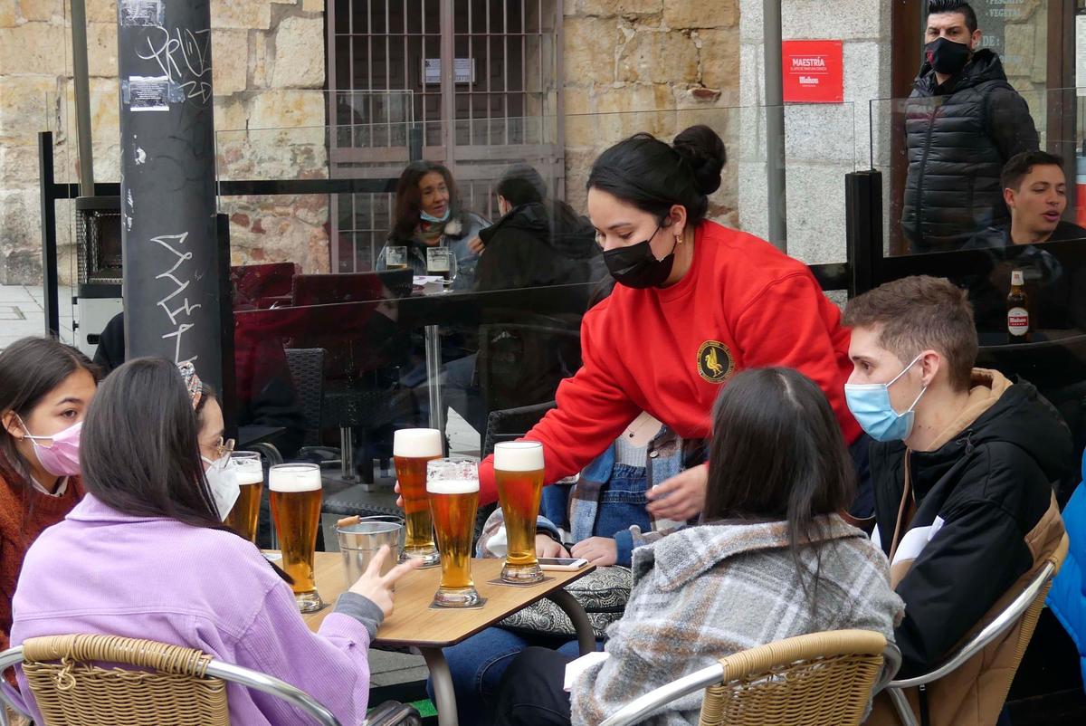 Una camarera sirve cervezas en una terraza del centro.