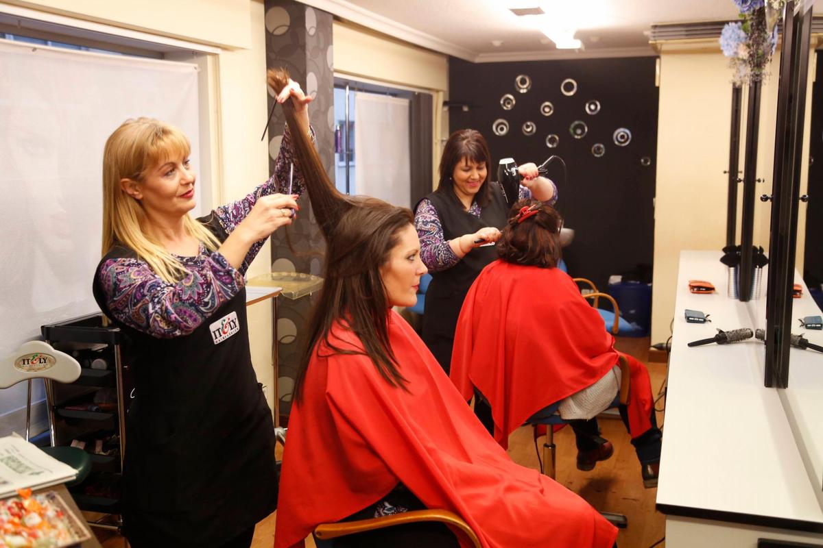 Trabajadoras de una peluquería atienden a sus clientas.