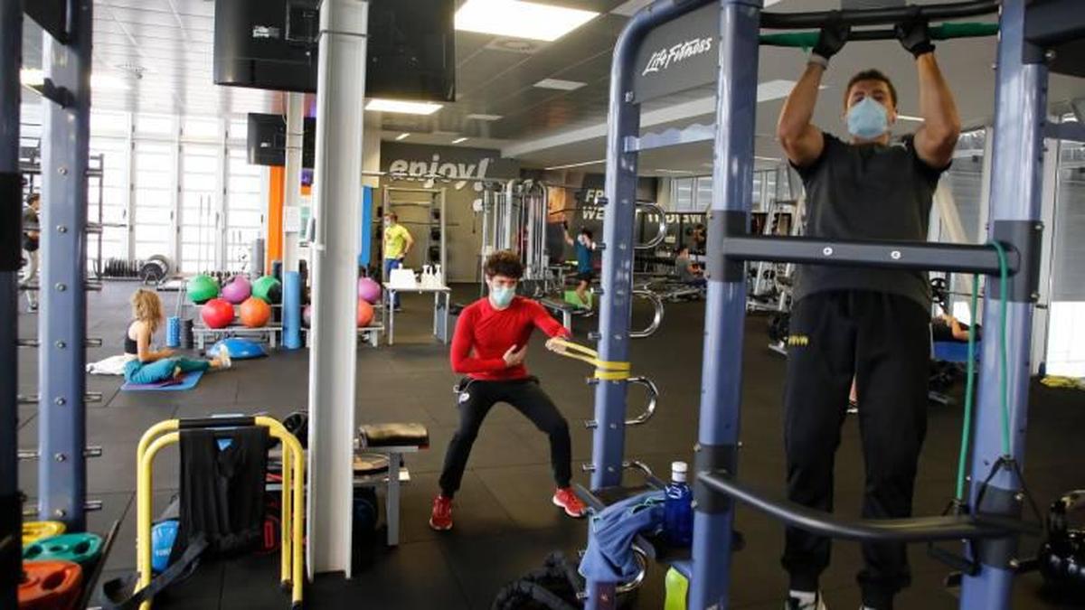 Usuarios con mascarilla en el interior del gimnasio Enjoy Aldehuela.