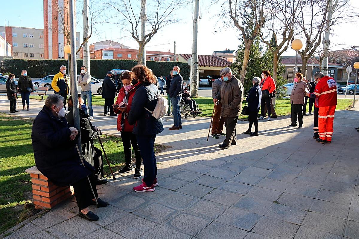 Mayores y familiares esperando su turno para vacunarse en el exterior del centro de salud.