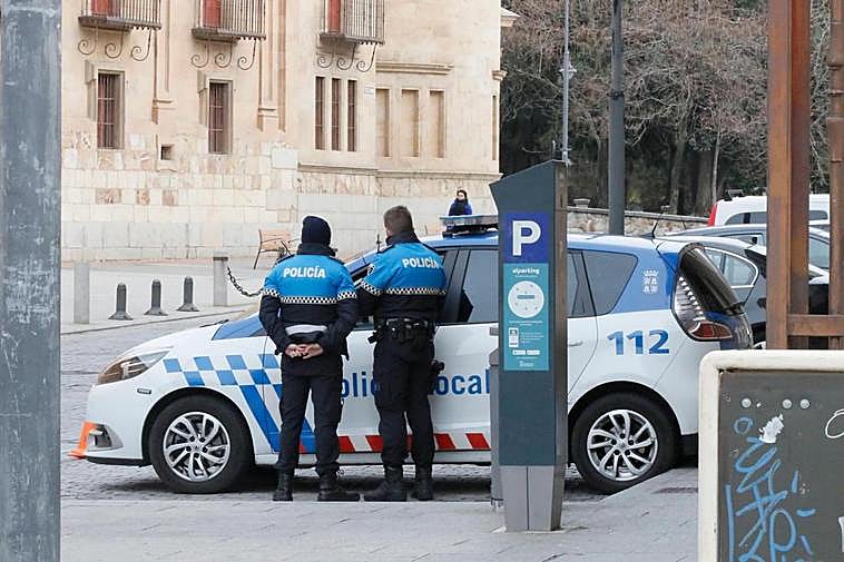 Dos agentes de la Policía Local junto a su coche.