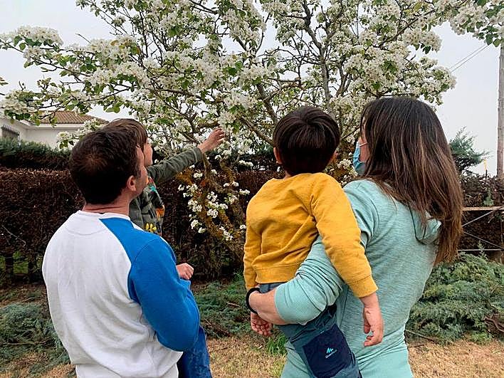 Leví y Ana sostienen en brazos a sus pequeños Diego y David. El pequeño en acogimiento no aparece en la imagen por su protección.