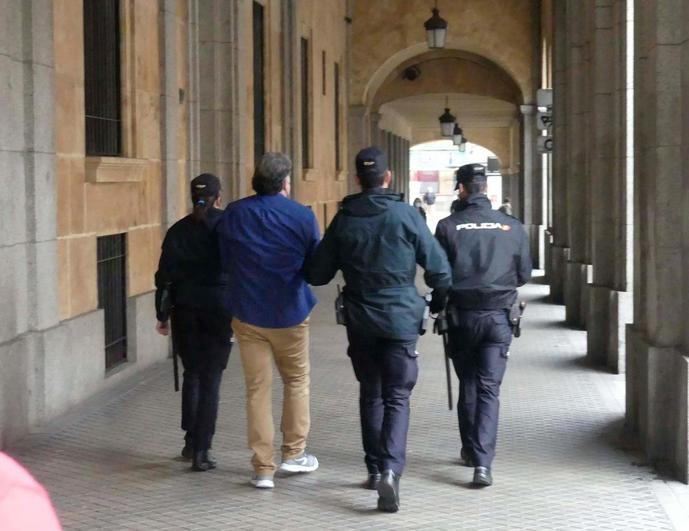 Momento en el que el acusado entra en la Audiencia Provincial custodiado por agentes de la Policía Nacional.