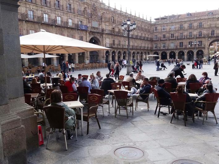 Varios grupos de personas disfrutando de las terrazas en la Plaza Mayor