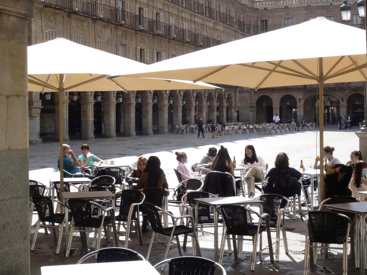 Varias personas consumiendo en una terraza de la Plaza Mayor de Salamanca.