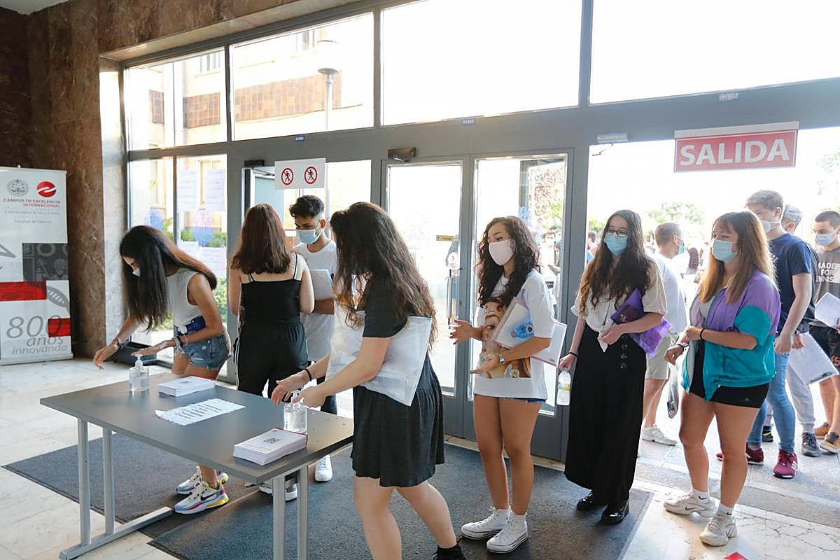 Estudiantes de la EBAU aplicándose el gel desinfectante a la entrada de la Facultad de Ciencias.