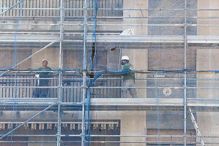 Trabajadores de la construcción, en las obras de rehabilitación de la fachada de un edificio.