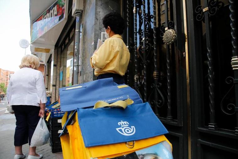 Una cartera, junto a su carro, realiza su servicio en la capital