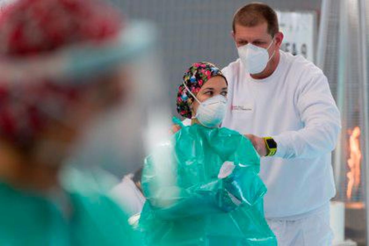 Una trabajadora sanitaria se protege para realizar tests de antígenos.