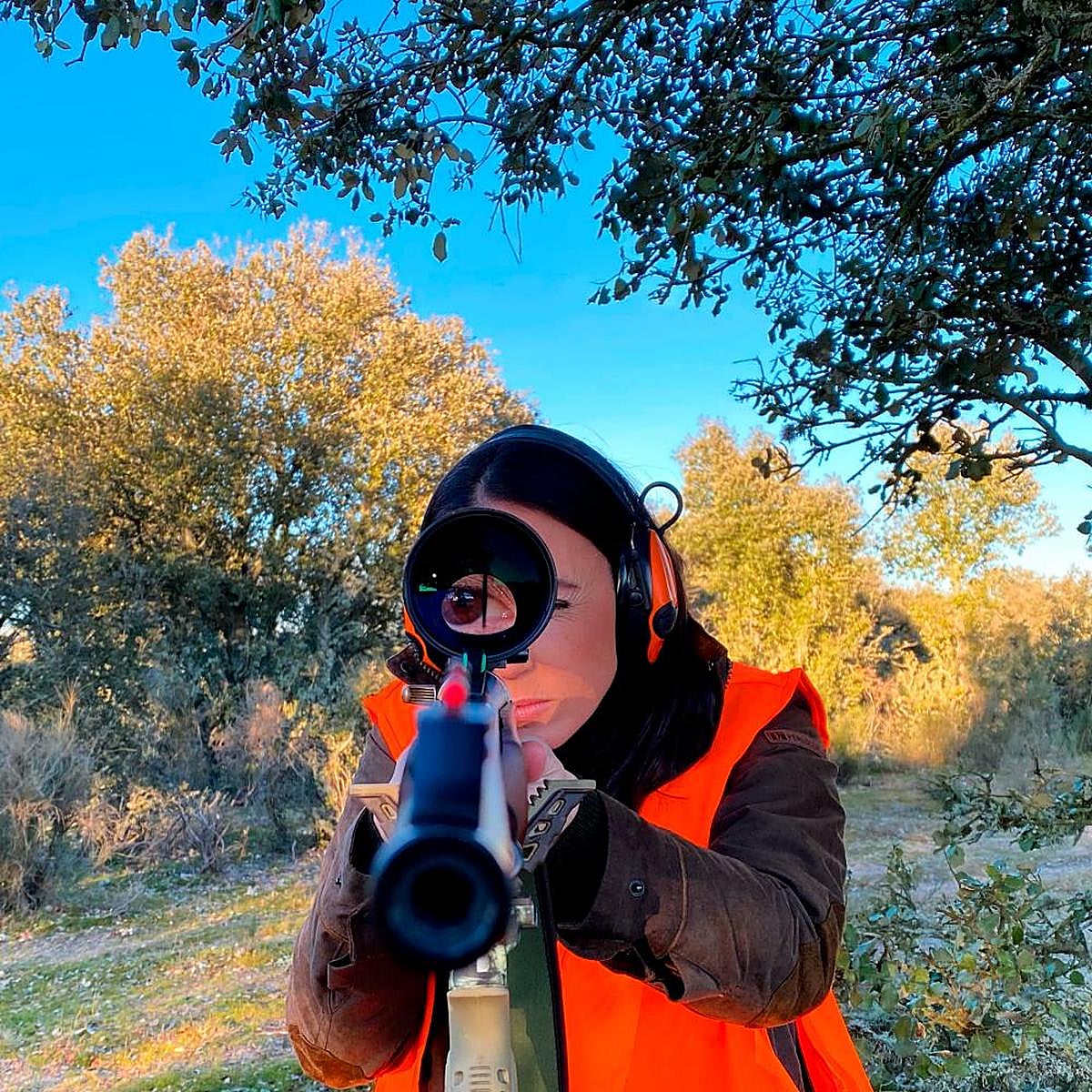Una cazadora apunta con su arma.