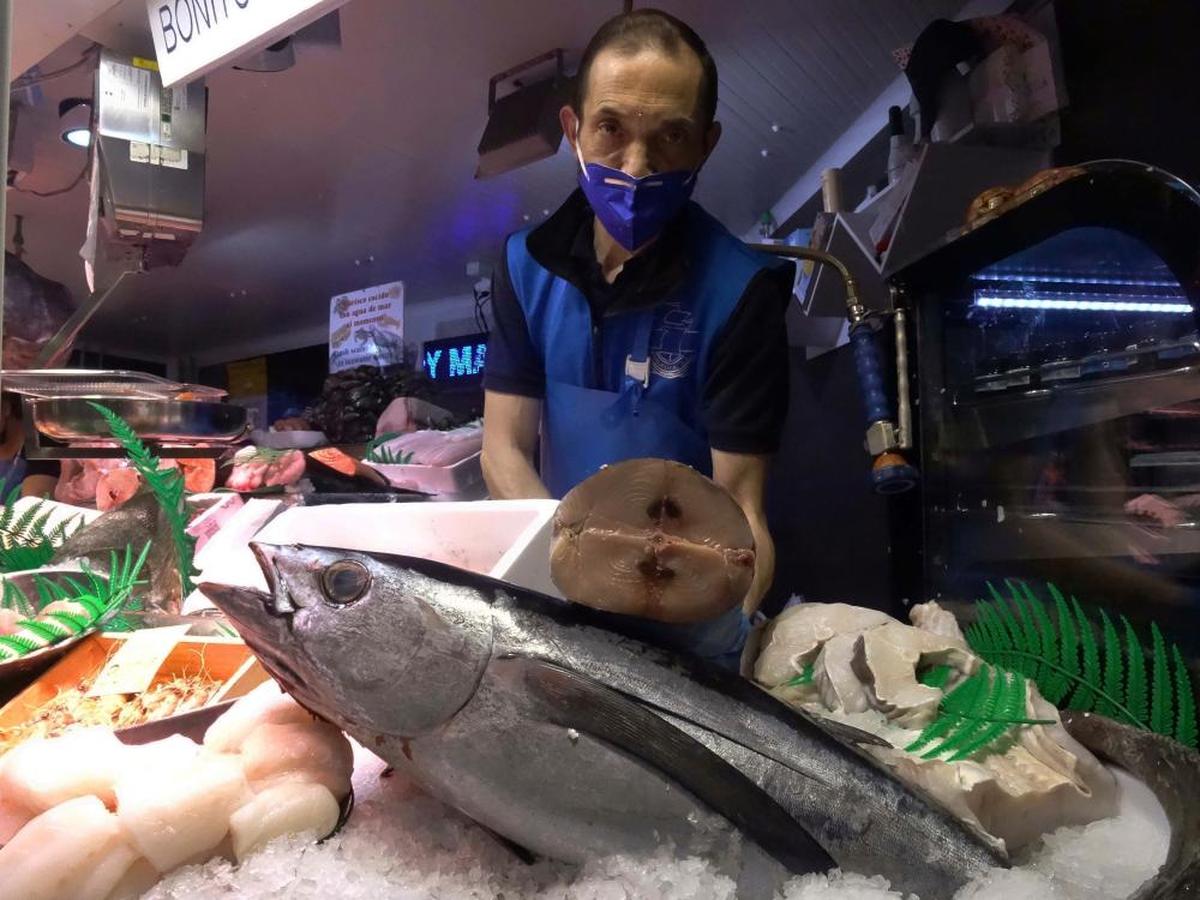 Un pescadero muestra el corte de la pieza de un bonito.