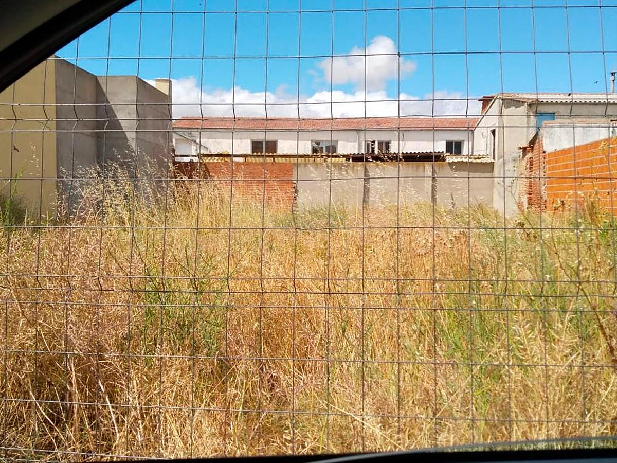 Un solar situado en pleno casco urbano y lleno de maleza seca con peligro de incendio.