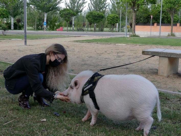 María Pinto paseando y acariciando a su mascota en un parque de Salas Bajas.