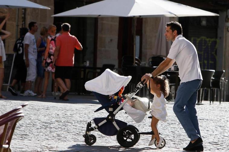 Un padre paseando con sus dos hijos.