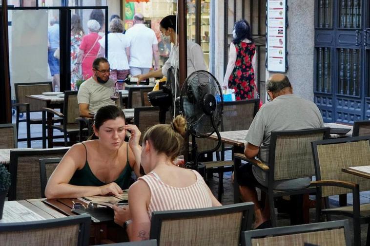 Un establecimiento de hostelería con una camarera atendiendo a un cliente.