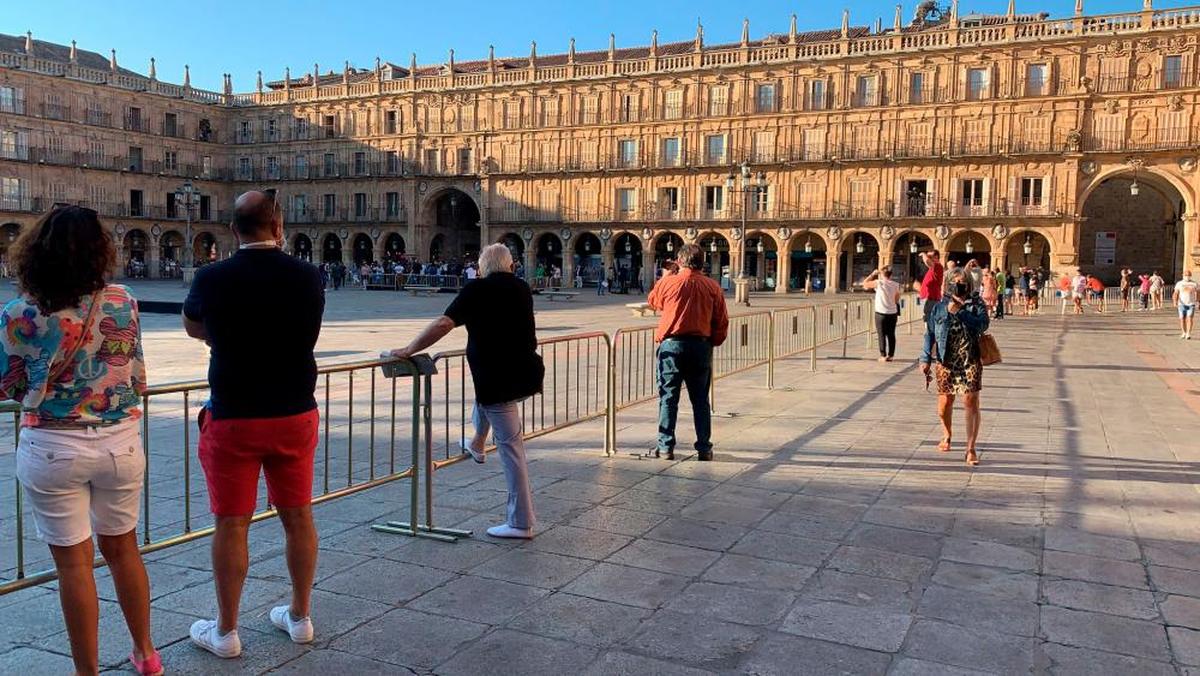 Algunos curiosos esperando a la foto de familia en la Plaza Mayor.