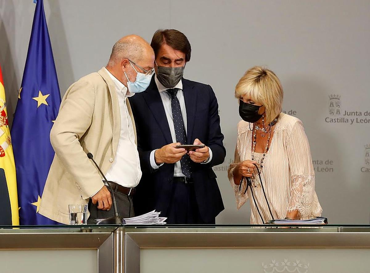 Francisco Igea, Juan Carlos Suárez Quiñones y Verónica Casado consultan un teléfono.