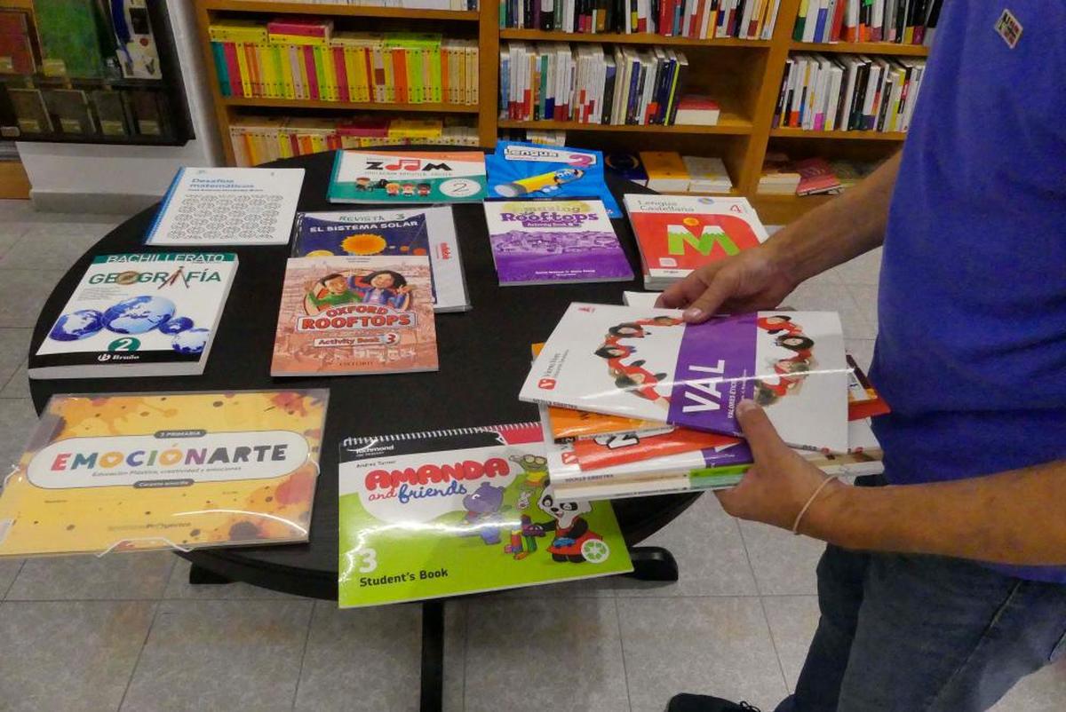 Un librero salmantino prepara lotes de libros de texto para este próximo curso.