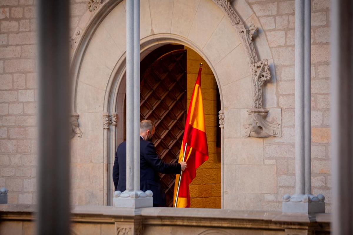 Un hombre retira la bandera de España en la Generalitat