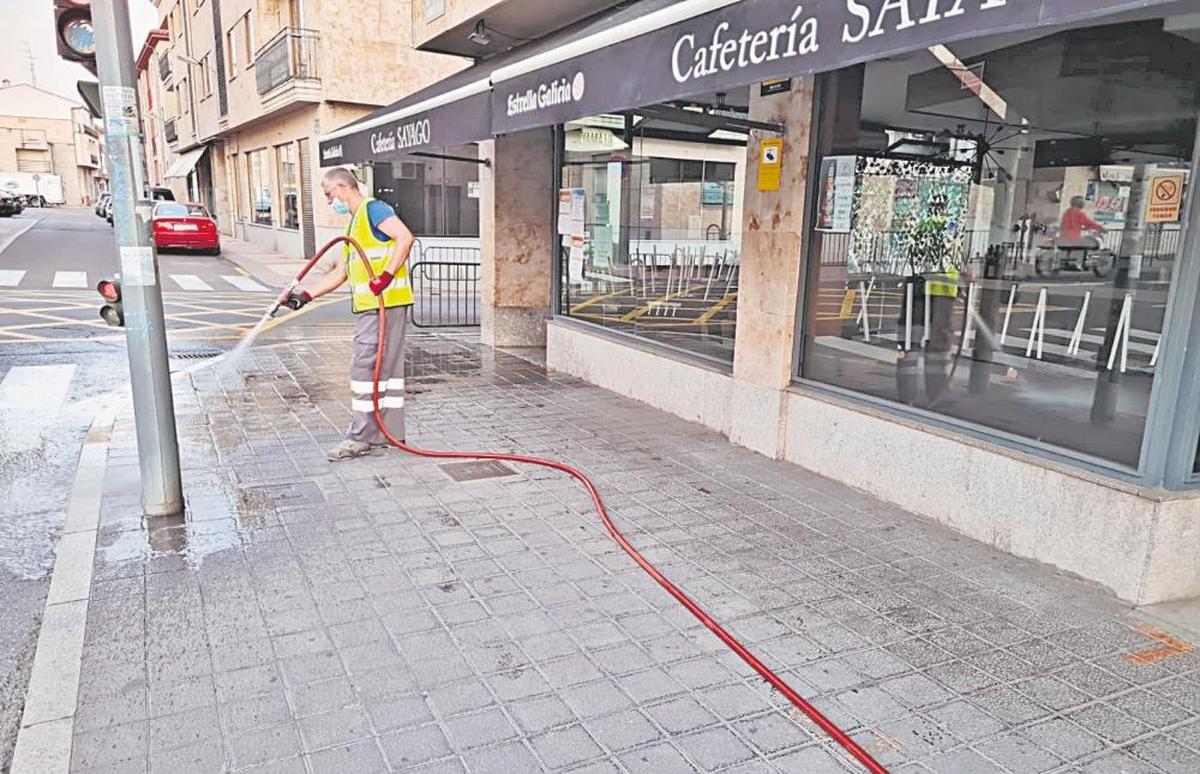 Un operario de Villamayor realiza la limpieza de las micciones de los perros, con agua a presión