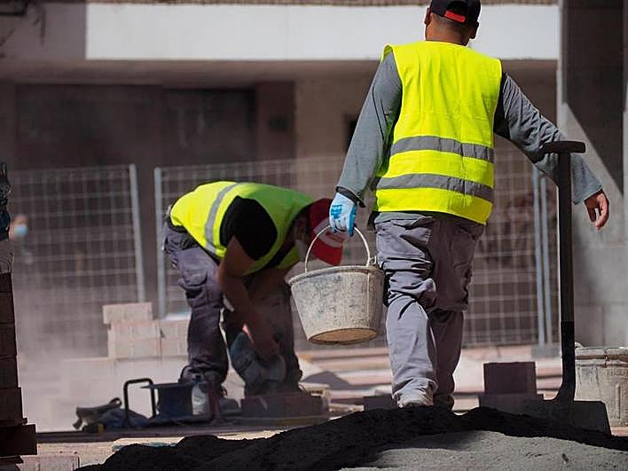 Trabajadores del sector de la construcción, durante el arreglo de una calle en la ciudad.