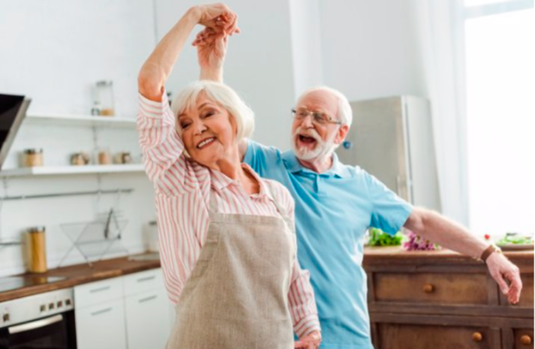 Una pareja de personas mayores baila con felicidad