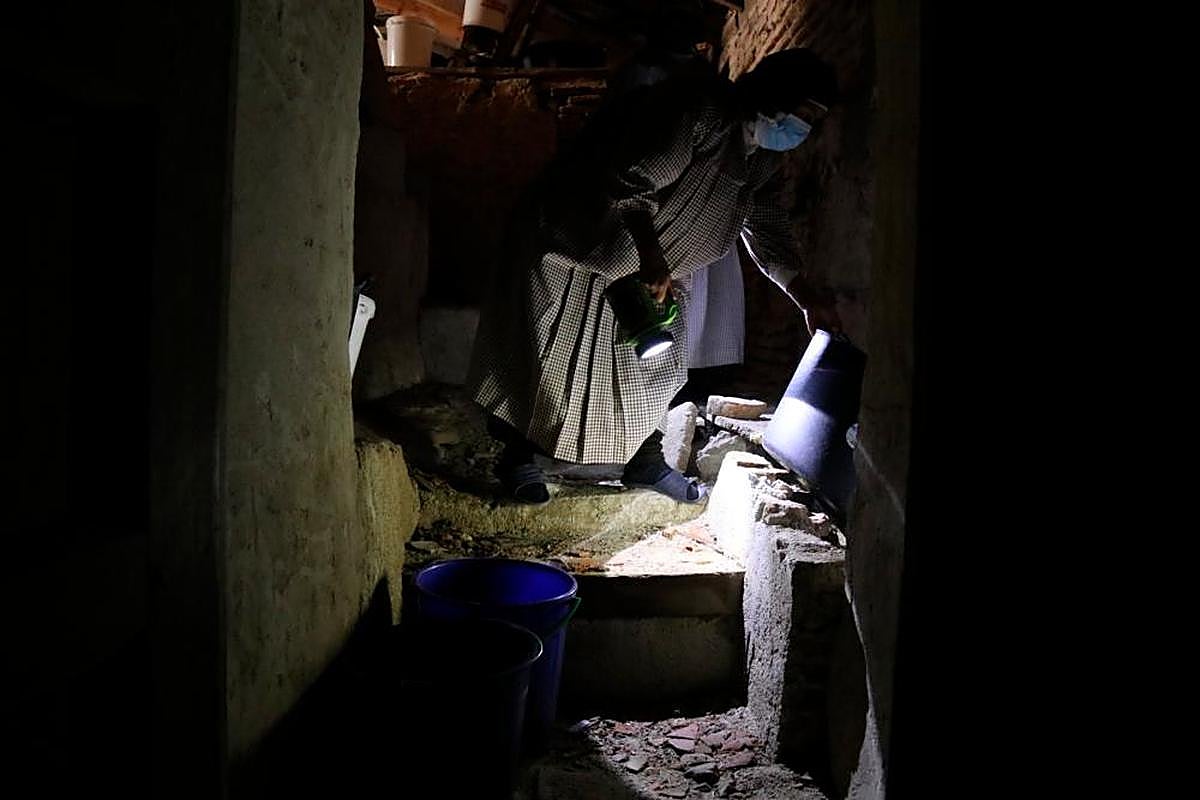 Una religiosa revisando los cubos repartidos por la cubierta para recoger el agua de lluvia.