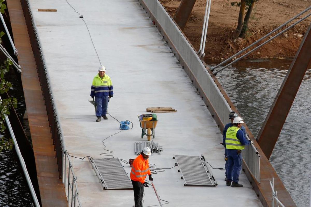 Trabajadores de la construcción en la pasarela entre Huerta Otea y los huertos urbanos.