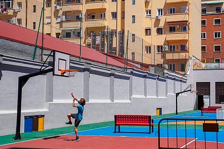 Un niño descansando en el patio del colegio.