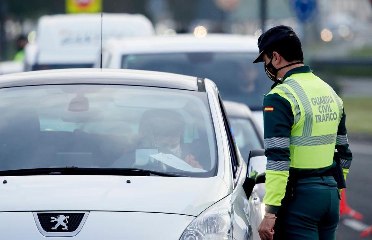 Un agente de la Guardia Civil le pide la documentación al conductor de un vehículo durante un control