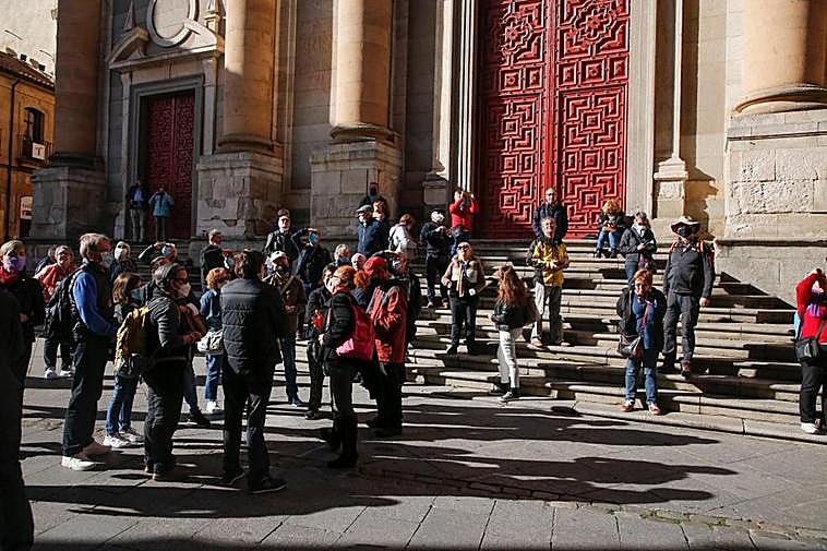 Un grupo de turistas extranjeros, en las escaleras de la iglesia de la Clerecía