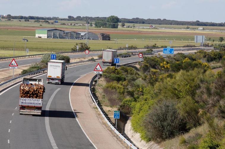 Varios camiones circulando por una autovía.