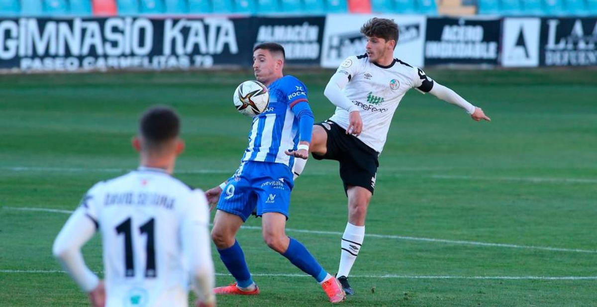 Antonio Amaro defiende a un jugador del Avilés