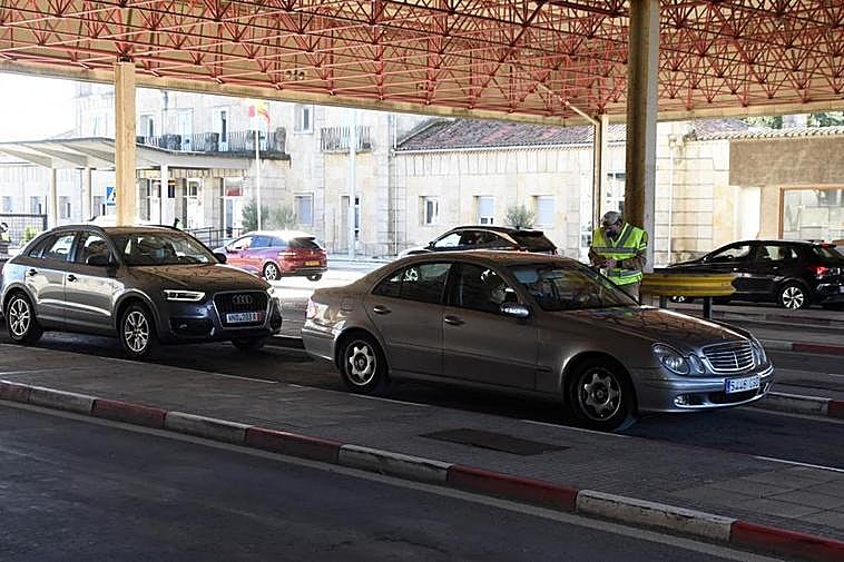 Un agente de la Guardia Nacional Republicana solicita el certificado covid a dos viajeros españoles en la frontera oñorense