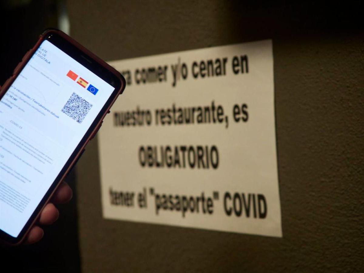 Una persona muestra su certificado de vacunación contra la covid.